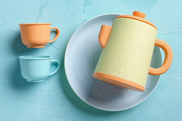 Plate with cups and teapot for baby on grunge blue background