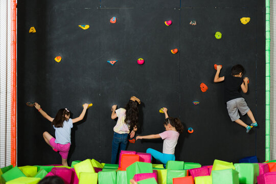 Happy kids in the playground having fun rock climbing