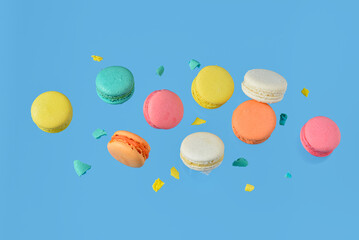 Fototapeta premium Flying sweet macaroons on blue background