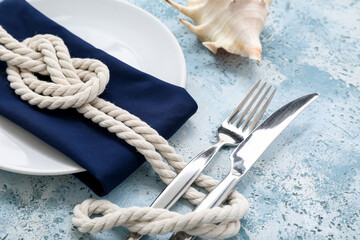 Beautiful table setting with marine decor on blue background
