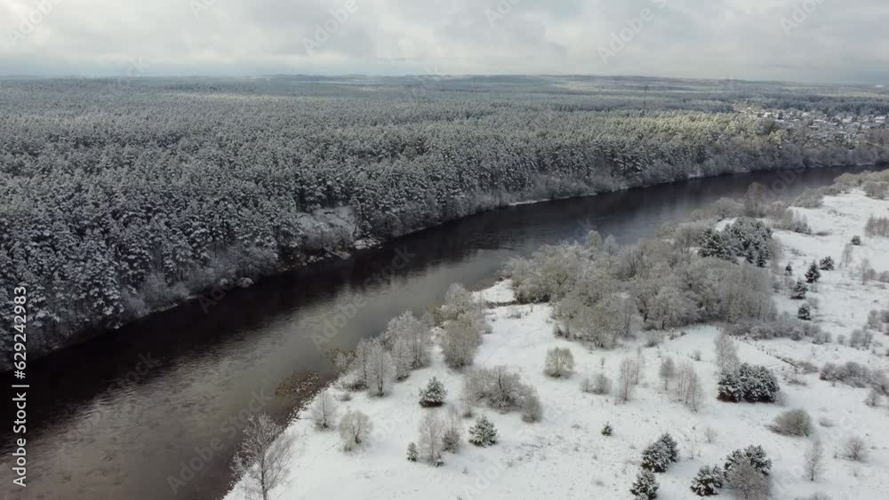 Canvas Prints Drone footage flyover snow forest trees by a river under cloudy sky on the horizon