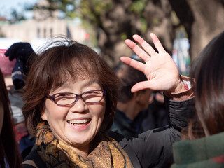 Happy Japanese lady waving towards the camera - 629243704
