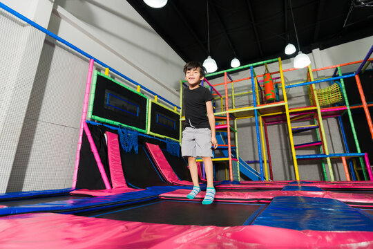 Young boy playing and jumping in the trampoline playground