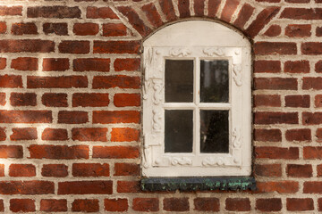 Fototapeta na wymiar Red brick wall with white arched window