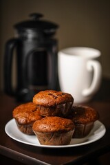 a plate full of freshly baked muffins sitting on top of a wooden table