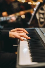 Closeup shot of the hands of a pianist on a piano. - obrazy, fototapety, plakaty