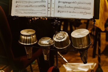 Trumpet mutes in a row with sheet music on a stand.