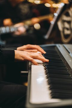 Closeup shot of the hands of a pianist on a piano.