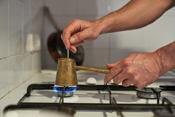 Unrecognizable person brewing coffee on gas stove