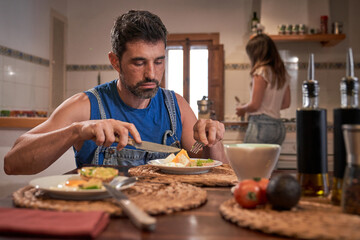 Serious man having breakfast at wooden table