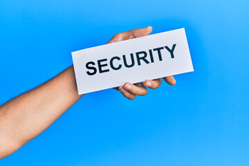 Hand of caucasian man holding paper with security word over isolated blue background