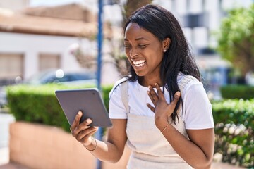 Young african american woman smiling confident watching video on touchpad at park