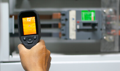 Professional Electrician use thermal infrared camera or thermometer scaning electrical system for...