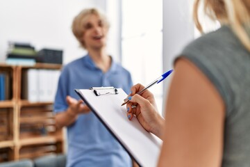 Young blond man patient having mental therapy standing at psychology clinic