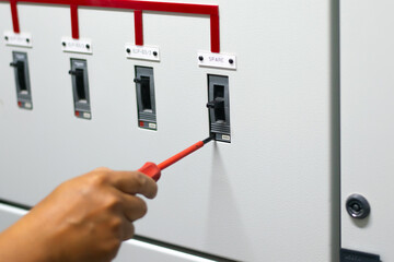 Electrician work tester measuring voltage and current of power electric line in electrical cabinet control, Professional man uses tool commissioning test or checking circuit for protection system.