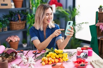 Young woman florist smiling confident using smartphone at florist