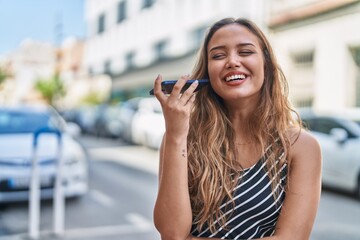 Young beautiful hispanic woman smiling confident listening audio message by the smartphone at street