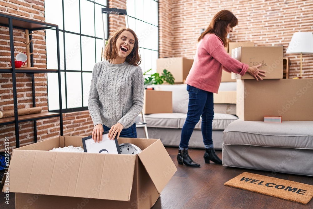 Sticker Two women mother and daughter unpacking cardboard box at new home