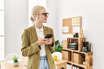 Young blonde woman business worker using smartphone working at office