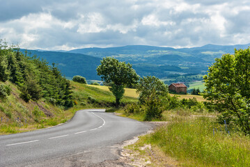 Rural scene with a country road in a French agricultural landscape and with mountains in the background.
