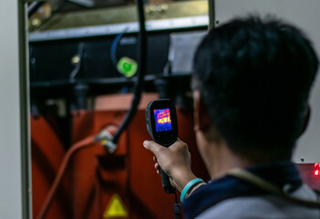 Professional Electrician use thermal infrared camera or thermometer scanning electrical system for preventive maintenance,Industrial thermography,Thermal image of power electric.