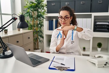 Young hispanic woman wearing doctor uniform and stethoscope doing time out gesture with hands, frustrated and serious face