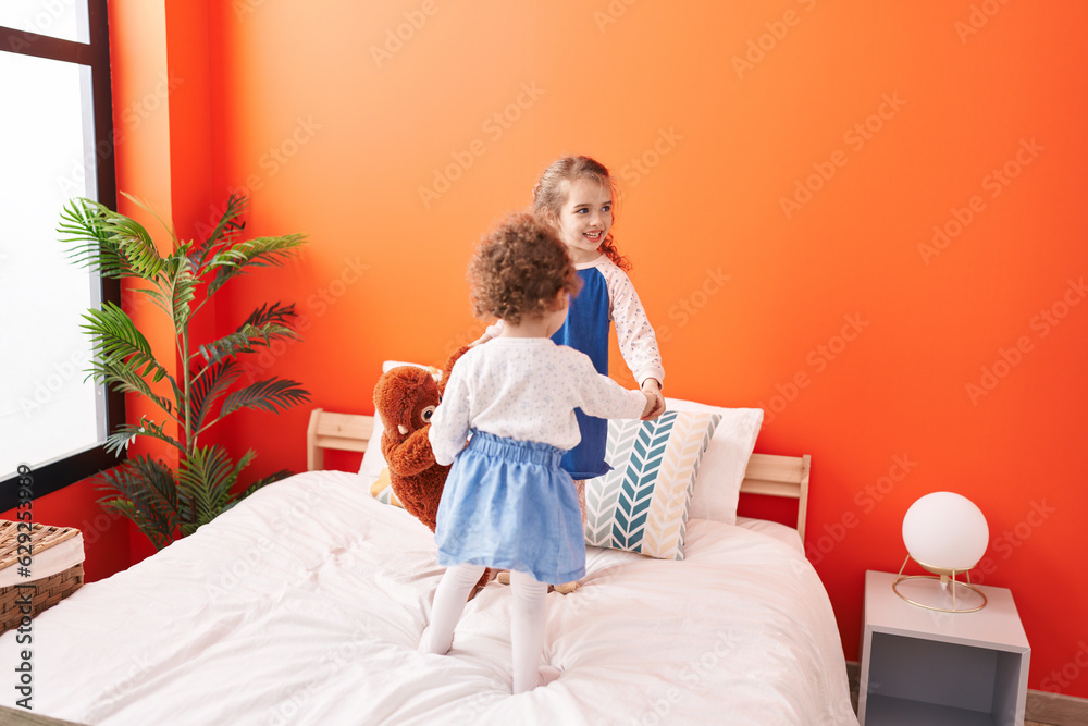 Poster Adorable girls smiling confident standing on bed at bedroom