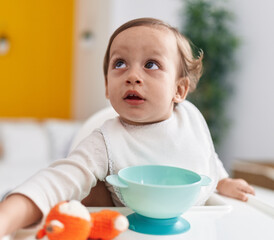 Adorable hispanic boy sitting on highchair at bedroom