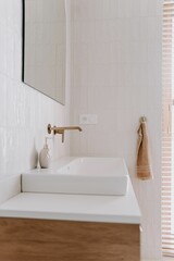 Modern bathroom featuring a white porcelain sink in front of a large mirror