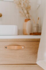 Fototapeta premium Modern wood bathroom vanity with a white porcelain sink and a white hand towel