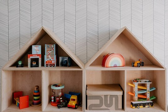 Wooden book shelves with brightly colored toys and books neatly arranged on the