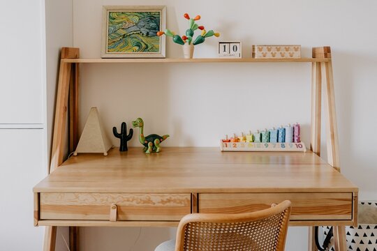 Wooden kid's table and chair set situated in a cozy room with various toys