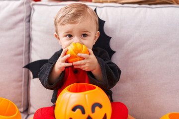 Adorable caucasian boy wearing bat costume having halloween party at home