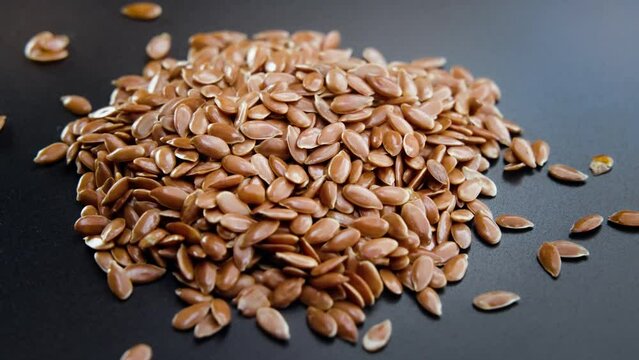 Close-up shot of linseed rotating on a dark background