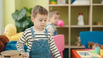 Adorable boys standing with relaxed expression playing at kindergarten