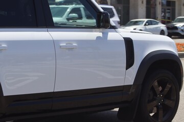 Obraz na płótnie Canvas White SUV in motion closeup. Modern new SUV background image.
