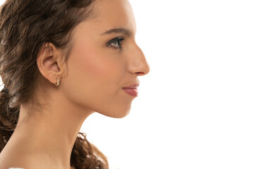 Profile portrait of a beautiful serious young woman, a nose with a hump on white background