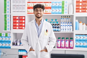 Young arab man pharmacist smiling confident standing at pharmacy