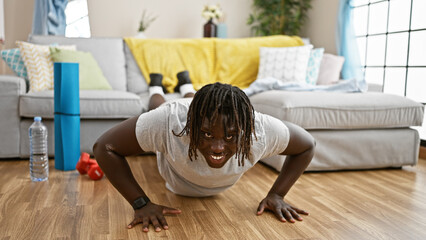 African american man training push up smiling at home - obrazy, fototapety, plakaty