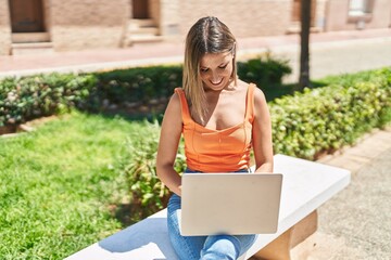 Young beautiful hispanic woman smiling confident using laptop at park