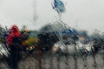 City road seen through rain drops on the car windshield.