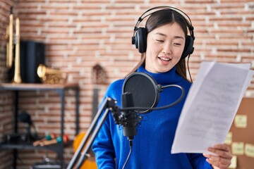 Chinese woman artist singing song at music studio