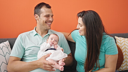 Family of three bonding sitting on the sofa at home