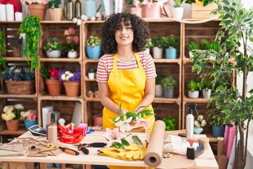 Young middle eastern woman florist make bouquet of flowers at florist