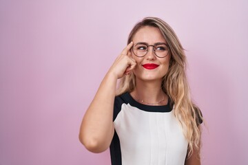 Young beautiful hispanic woman business worker smiling confident doing idea gesture with finger on head over isolated pink background