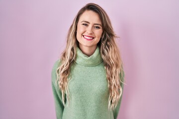 Fototapeta premium Young caucasian woman standing over pink background with a happy and cool smile on face. lucky person.