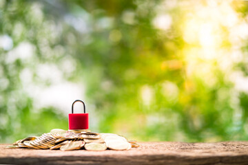 Red master key put on the stacked gold coin is many and security on the wood on sunlight in the...