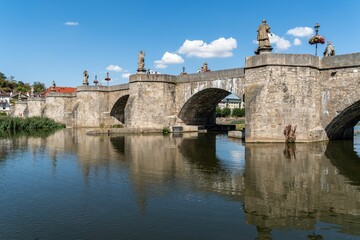 Beautiful stone bridge with ornamental statues spanning a river in Wurzburg, Bavaria, Germany.