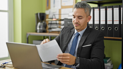 Fototapeta na wymiar Young hispanic man business worker reading letter at office