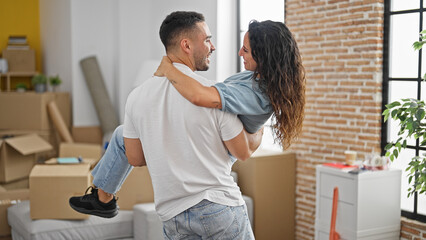 Man and woman couple holding girlfriend on arms smiling at new home